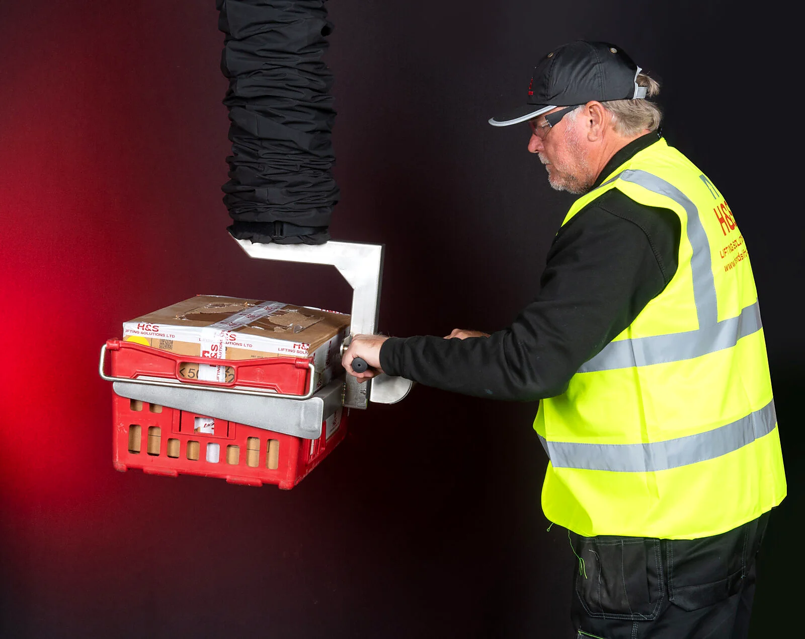 Vacuum lifting equipment handling a basket or product load.